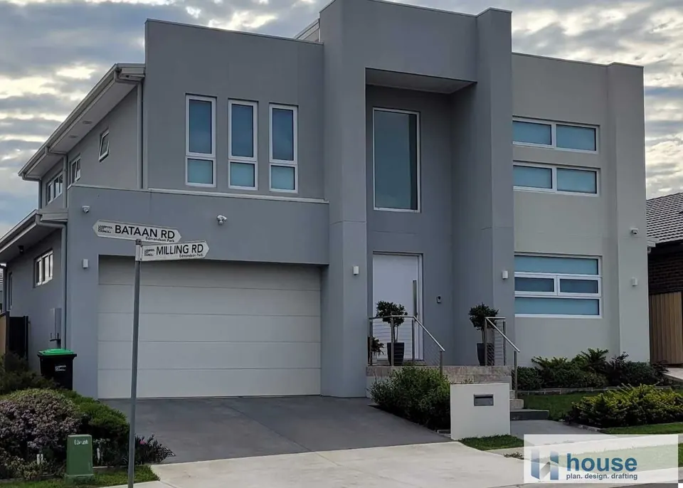 Grey rendered double-storey corner home with a double garage